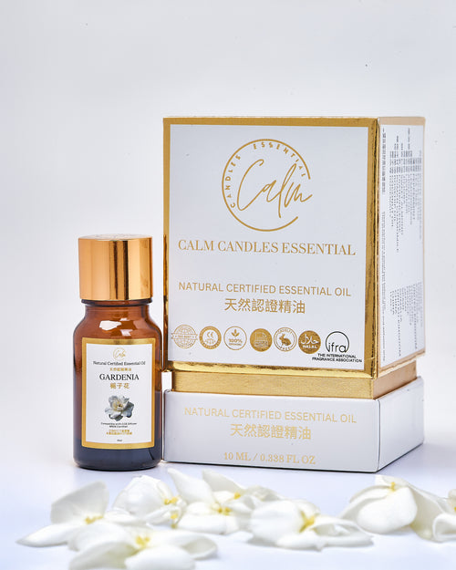 Calm candles essential oil bottle and packaging with white gardenia flowers on a light gray background